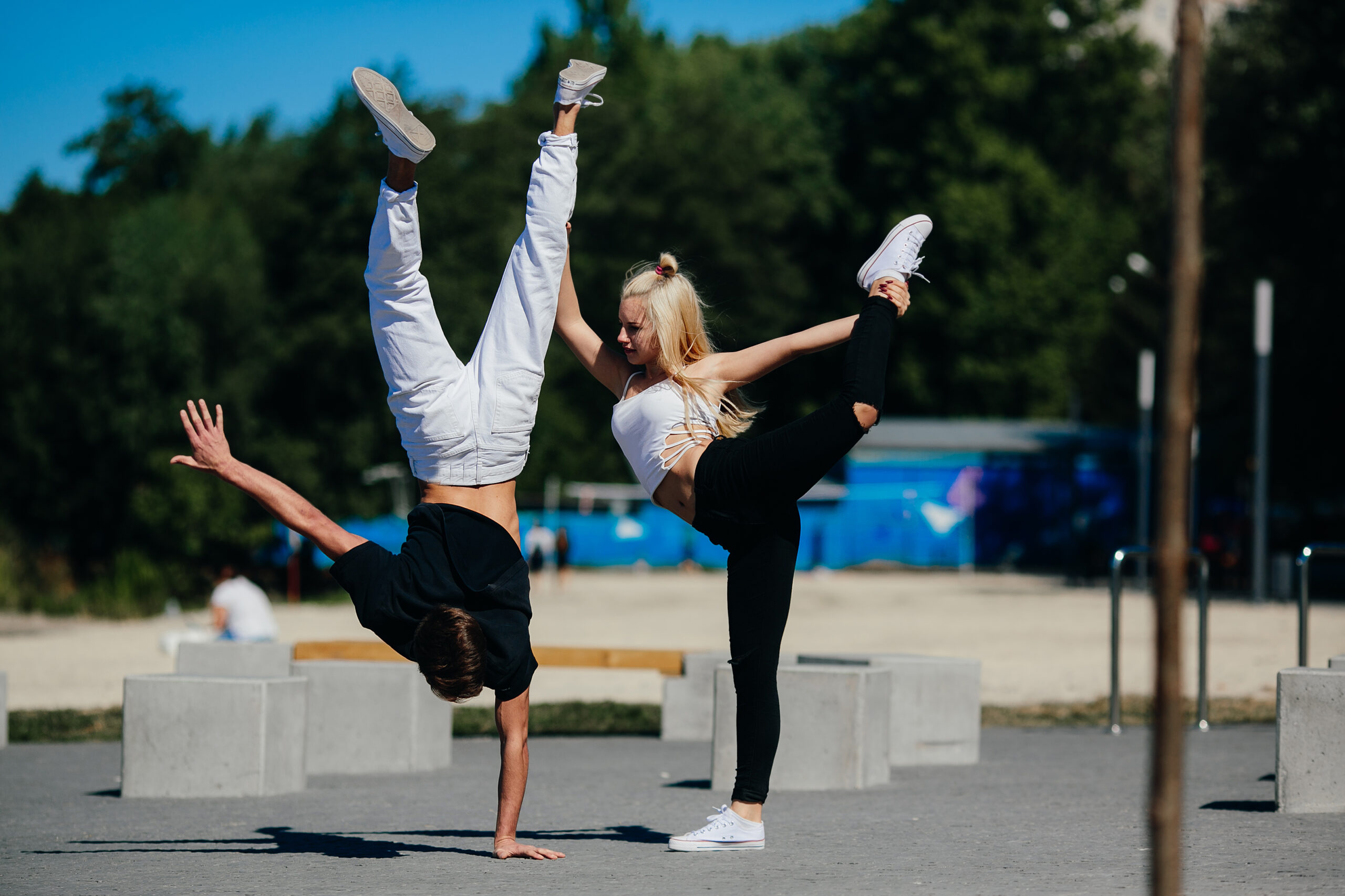 man and woman performing tricks in the park